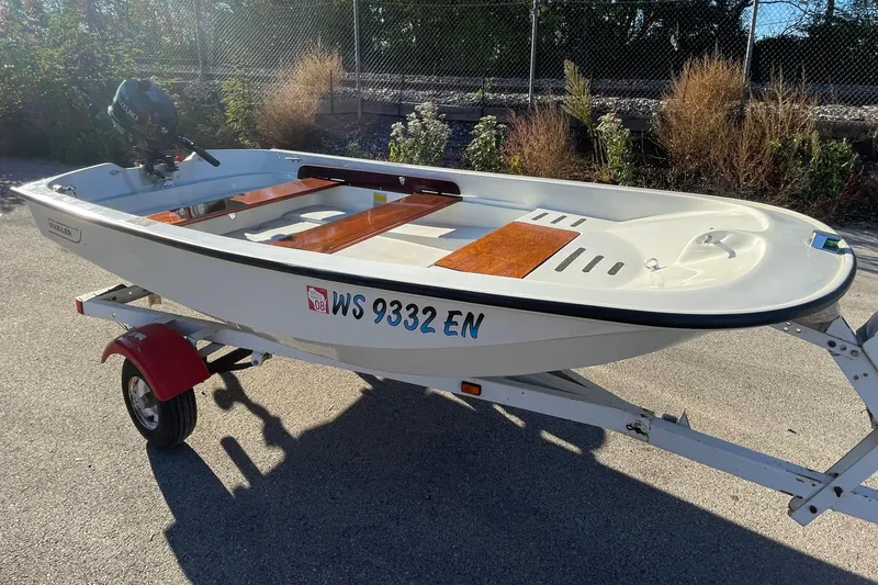 The Image of 1993 Boston Whaler Sport 11 boat on trailer, parked outdoors. - 0