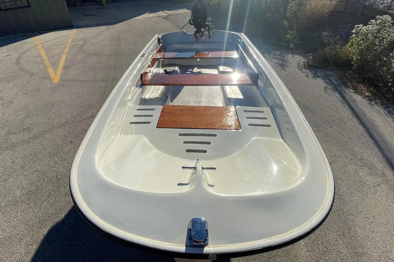 Slide: The Image of 1993 Boston Whaler Sport 11 boat with wooden seats, parked on pavement. - 4