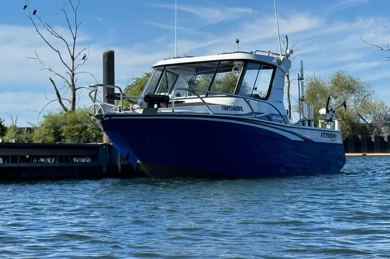 The Image of 2023 Extreme Boats 695 Game King on water near dock, clear sky background. - 0