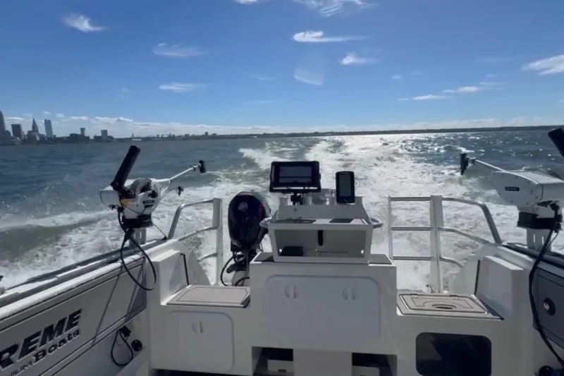 Slide: The Image of 2023 Extreme Boats 695 Game King cruising on open water with city skyline in background. - 10