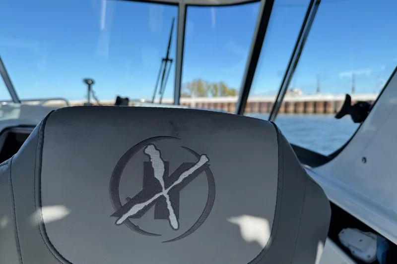 Slide: The Image of 2023 Extreme Boats 695 Game King interior with logo, overlooking water and dock. - 13