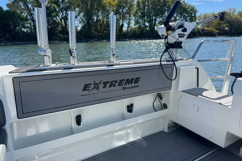 Slide: The Image of 2023 Extreme Boats 695 Game King, featuring fishing rod holders and sleek design on a sunny day. - 14