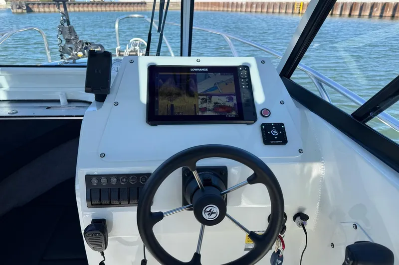 Slide: The Image of 2023 Extreme Boats 695 Game King dashboard with steering wheel and navigation display. - 19