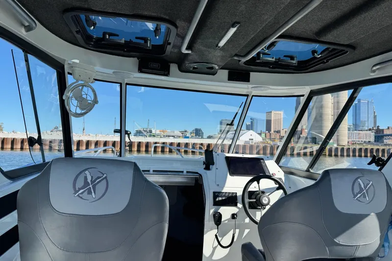 Slide: The Image of Interior view of 2023 Extreme Boats 695 Game King, showcasing helm and city skyline. - 20