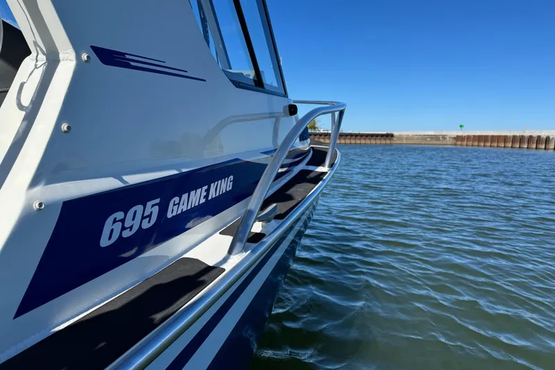 Slide: The Image of 2023 Extreme Boats 695 Game King on water, side view. - 25