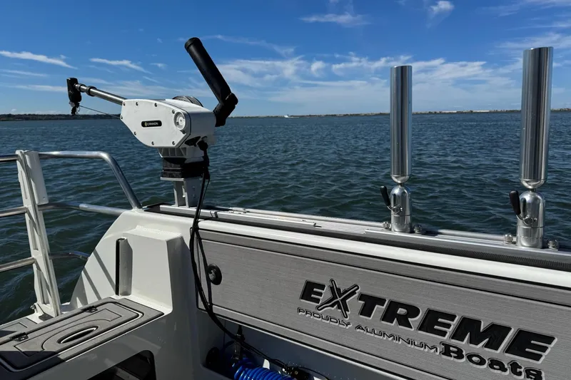 Slide: The Image of 2023 Extreme Boats 695 Game King on water, featuring fishing equipment and clear blue sky. - 27