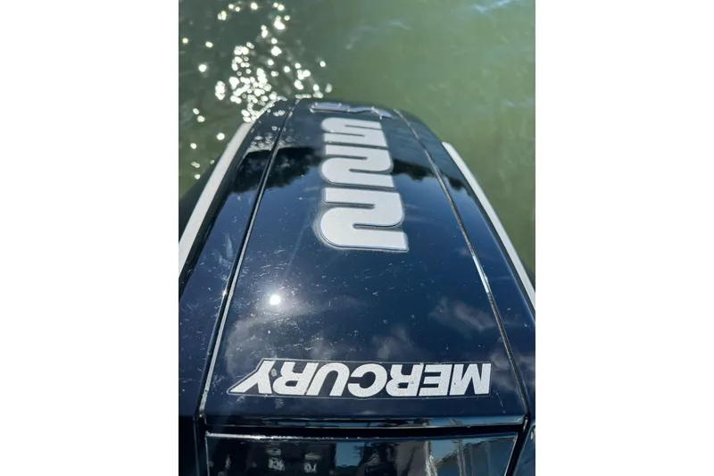 Slide: The Image of Mercury outboard engine on 2023 Extreme Boats 695 Game King, reflecting sunlight on water. - 32