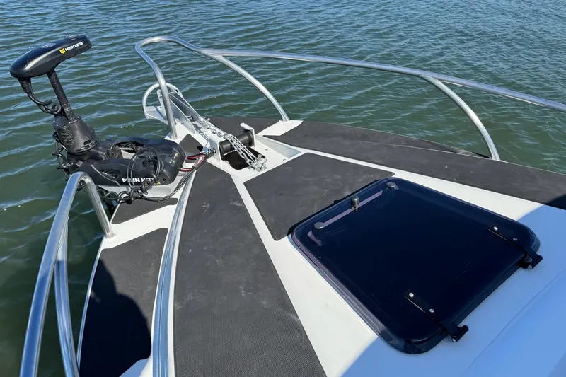 Slide: The Image of 2023 Extreme Boats 695 Game King bow with motor and hatch on water. - 5