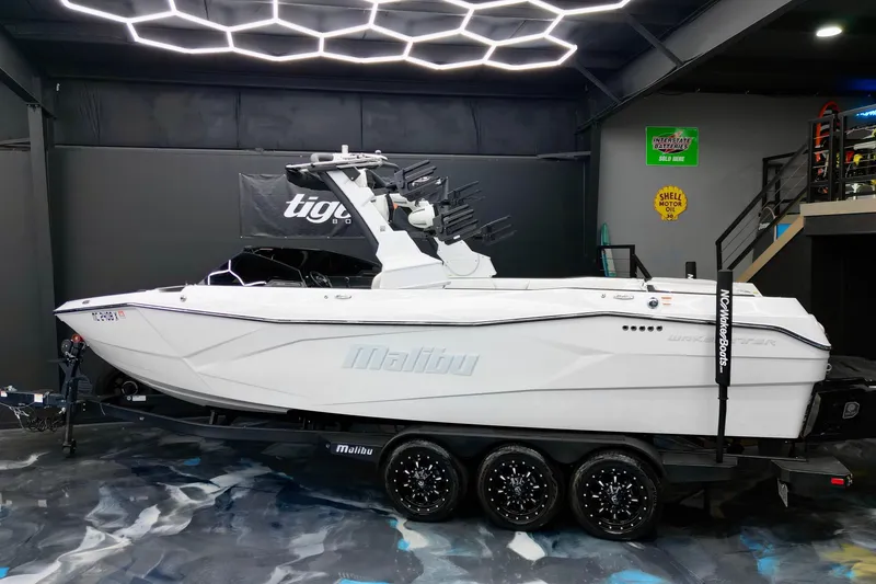 Slide: The Image of 2023 Malibu Wakesetter 26 LSV boat in showroom, sleek design, on trailer. - 4