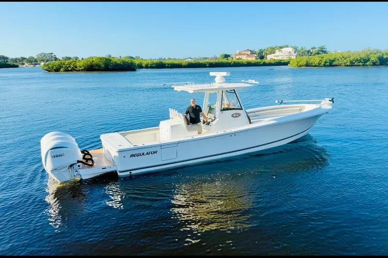 Slide: The Image of 2024 Regulator 34 C boat on calm water, featuring Yamaha engines and sleek design. - 1