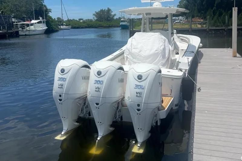 Slide: The Image of 2024 Regulator 34 C boat with triple Yamaha 300 V6 engines docked by the water. - 3