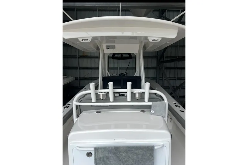 Slide: The Image of 2024 Regulator 34 c boat interior with rod holders and console, in a storage facility. - 5
