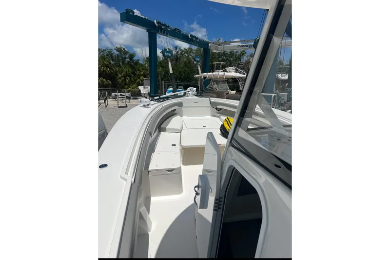 Slide: The Image of 2024 Regulator 34 C boat interior with open deck and seating under clear blue sky. - 8