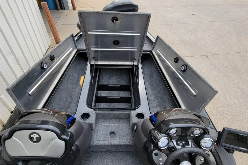 Slide: The Image of 2022 Bass Tracker PRO TEAM 190 boat interior with open storage compartments and control panel. - 17