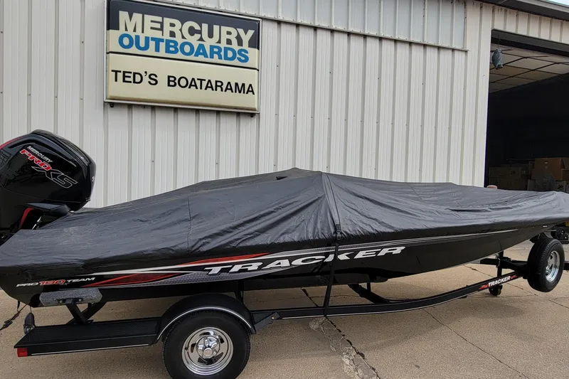 Slide: The Image of 2022 Bass Tracker PRO TEAM 190 boat covered, parked at Ted's Boatarama. - 2