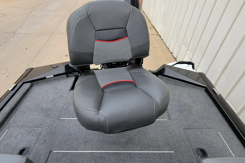 Slide: The Image of 2022 Bass Tracker PRO TEAM 190 boat seat, gray with red accents, on carpeted deck. - 23