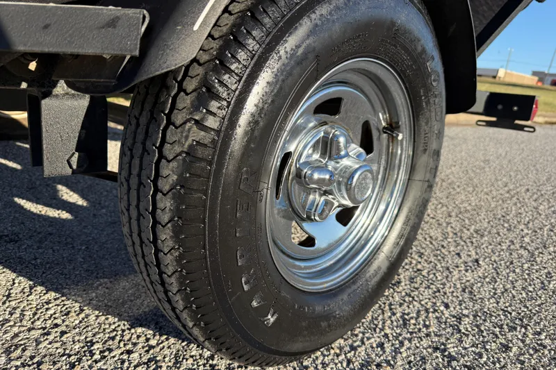 Slide: The Image of 2020 Tracker Pro Team 175 trailer tire on asphalt, showcasing shiny chrome wheel. - 15