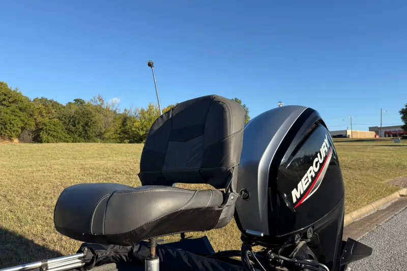 Slide: The Image of 2020 Tracker Pro Team 175 boat with Mercury engine, parked on grass under clear blue sky. - 16
