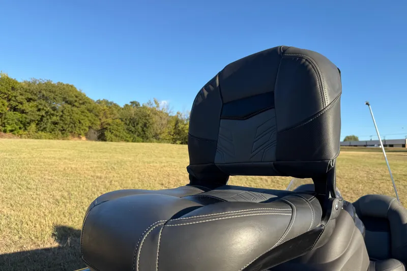 Slide: The Image of 2020 Tracker Pro Team 175 boat seat in a grassy field under clear blue sky. - 17