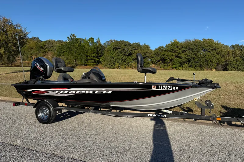 Slide: The Image of 2020 Tracker Pro Team 175 boat on trailer, parked on roadside with grassy background. - 3