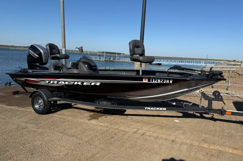 Slide: The Image of 2020 Tracker Pro Team 175 boat on trailer by the water, featuring a Mercury engine. - 39