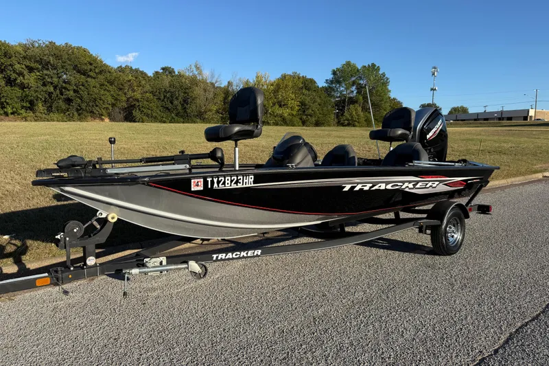 Slide: The Image of 2020 Tracker Pro Team 175 boat on trailer, parked on a road with grassy background. - 4