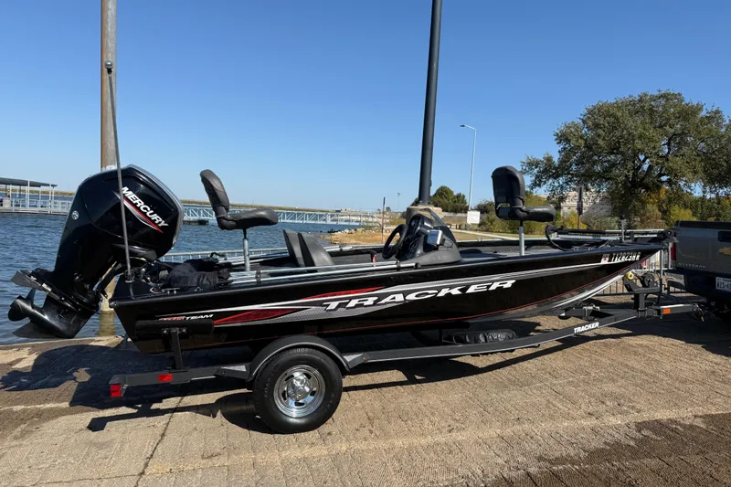 Slide: The Image of 2020 Tracker Pro Team 175 boat on trailer by the water, featuring Mercury engine. - 45