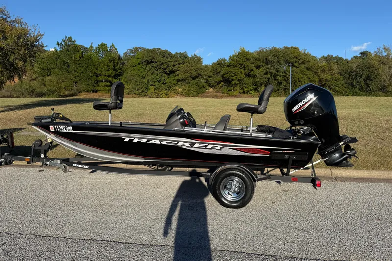 Slide: The Image of 2020 Tracker Pro Team 175 boat on trailer, parked on road with grassy background. - 6