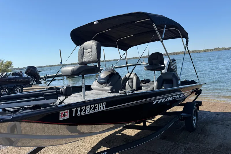 Slide: The Image of 2020 Tracker Pro Team 175 boat on trailer by a lake, under clear blue sky. - 60