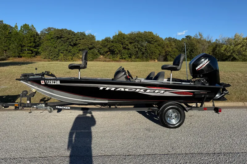 Slide: The Image of 2020 Tracker Pro Team 175 boat on trailer, parked on road with grassy background. - 8