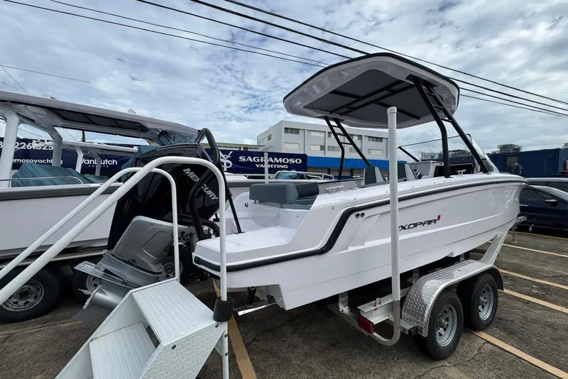 Slide: The Image of 2025 Axopar 25 Cross Top boat on trailer, featuring sleek design and Mercury engine. - 7