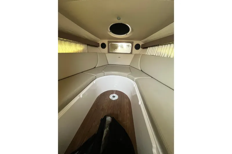 Slide: The Image of 2017 Regal 28 Express boat interior with beige seating and cup holders. - 22