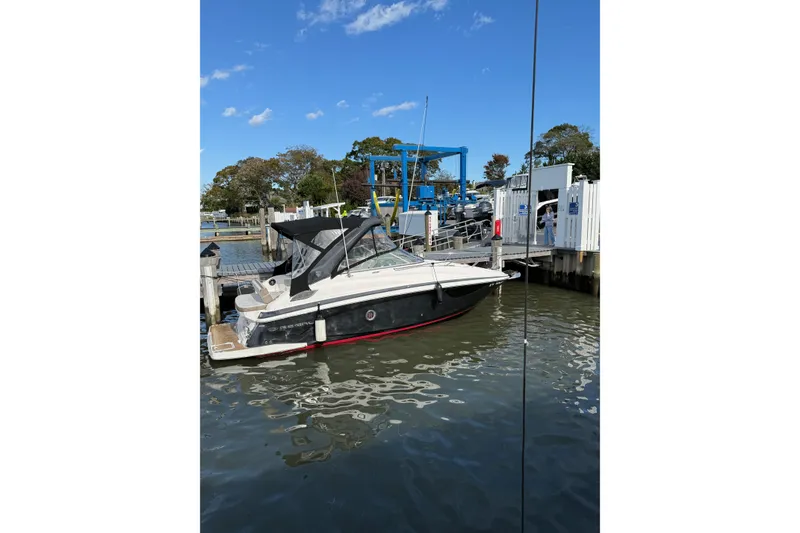 Slide: The Image of 2017 Regal 28 Express boat kitchen with microwave, wooden cabinets, and sink. - 28