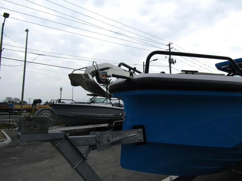 Slide: The Image of 2024 Axopar 37 Sun Top boat on trailer, blue hull, outdoor display. - 10