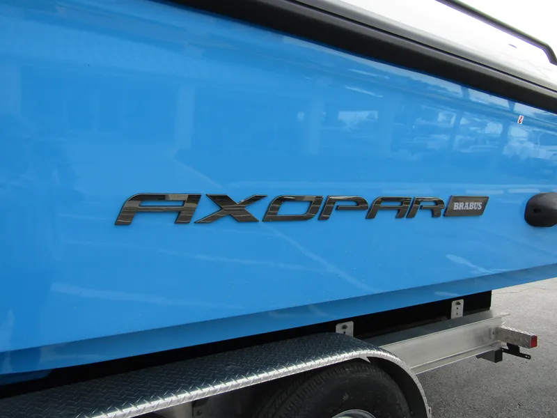 Slide: The Image of 2024 Axopar 37 Sun Top boat, blue hull, on trailer. - 13