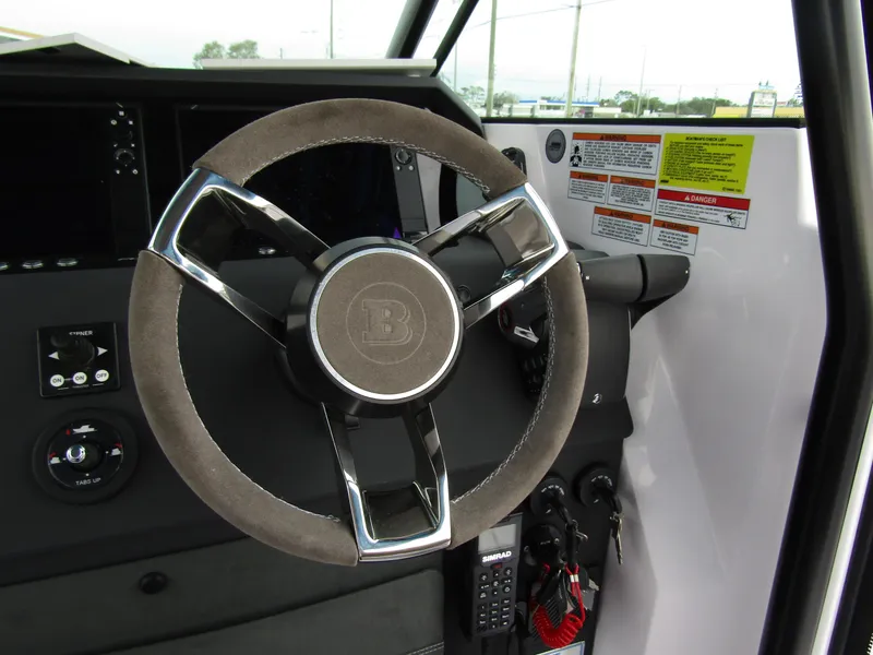 Slide: The Image of Steering wheel of 2024 Axopar 37 Sun Top boat, featuring modern controls and dashboard. - 29