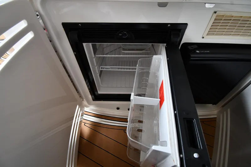 Slide: The Image of Open refrigerator on 2001 Sea Ray 540 Sundancer yacht, showcasing interior storage space. - 23