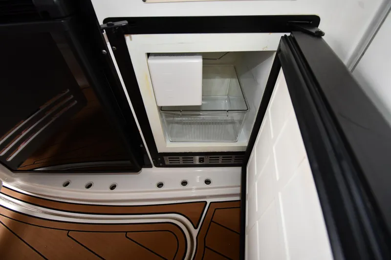 Slide: The Image of Open refrigerator on 2001 Sea Ray 540 Sundancer yacht, showcasing interior storage space. - 24
