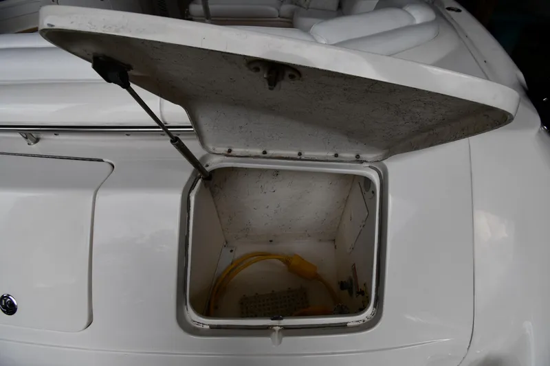 Slide: The Image of Open storage compartment on 2001 Sea Ray 540 Sundancer boat, showing interior and yellow cable. - 28