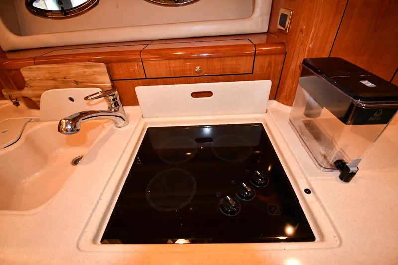 Slide: The Image of 2001 Sea Ray 540 Sundancer kitchen with stove, sink, and water filter. - 45