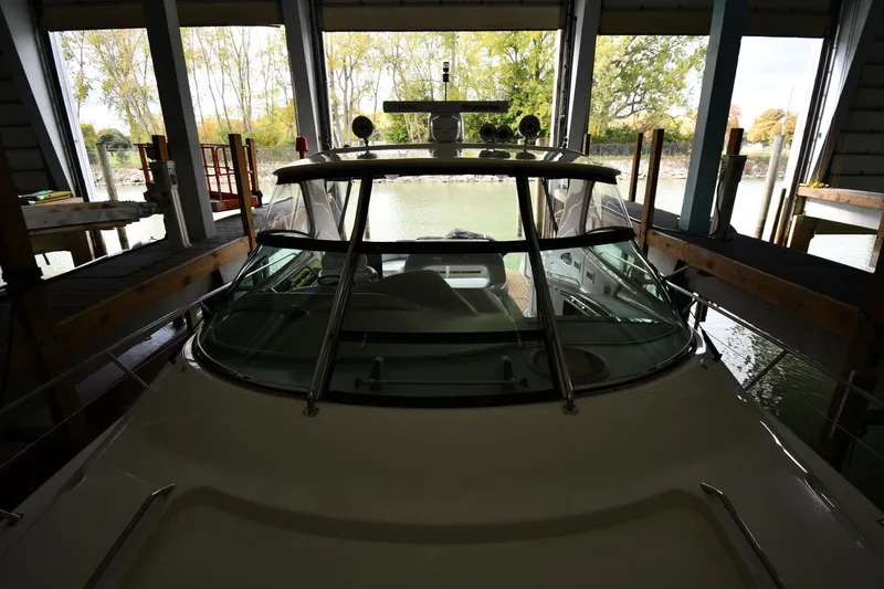 Slide: The Image of 2001 Sea Ray 540 Sundancer docked in a covered marina with scenic background. - 8