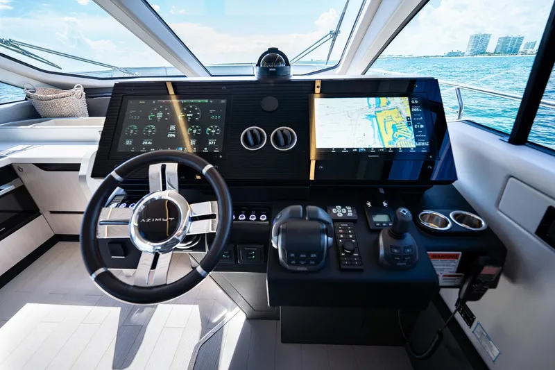 Slide: The Image of 2024 Azimut S7 yacht helm with advanced navigation displays and controls, overlooking the ocean. - 39
