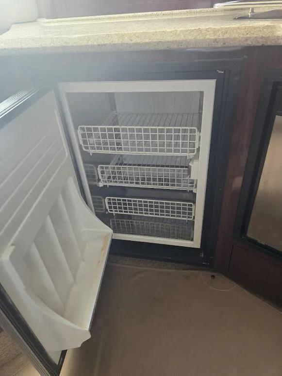 Slide: The Image of Open refrigerator with wire shelves inside a 2008 Sea Ray 40 Sundancer yacht. - 16