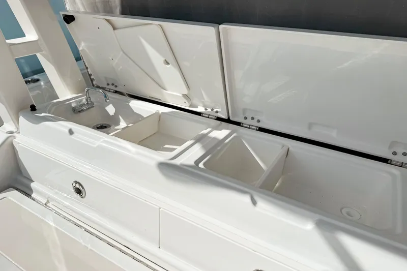 Slide: The Image of 2026 Pursuit S 328 Sport boat sink and storage compartments in white. - 15