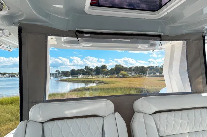 Slide: The Image of Interior view of 2026 Pursuit S 328 Sport boat with scenic waterfront backdrop. - 23