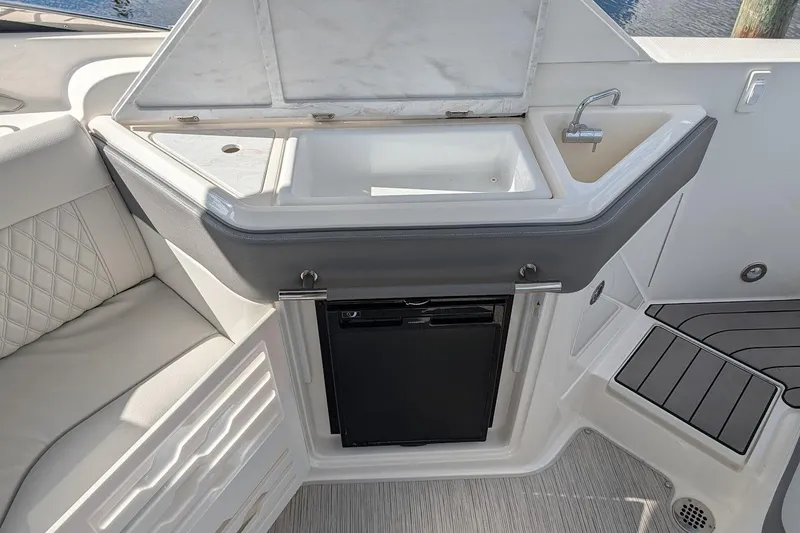 Slide: The Image of Luxurious seating and cabinetry on 2023 Sea Ray 310 SLX boat interior. - 10