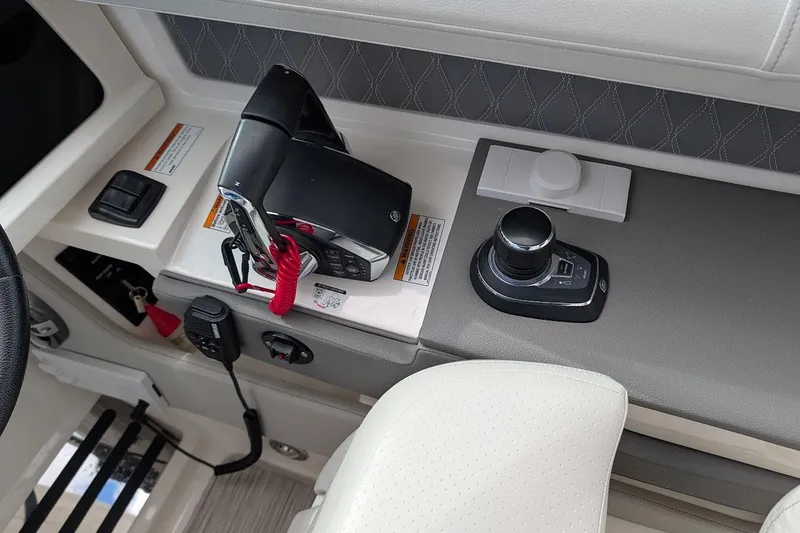 Slide: The Image of 2023 Sea Ray 310 SLX helm with modern controls and sleek steering wheel design. - 12