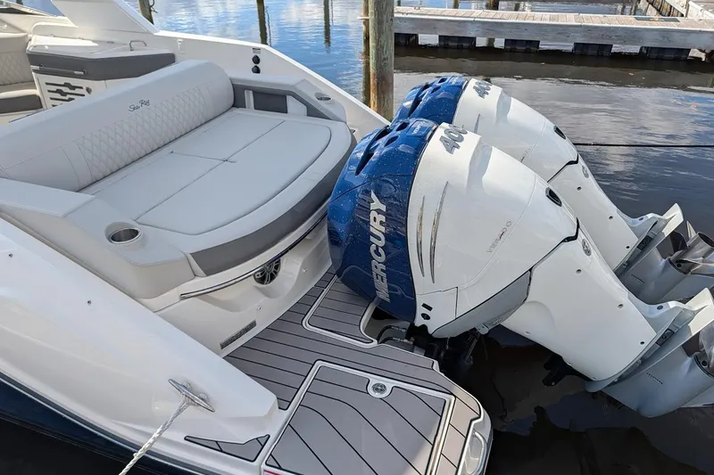 Slide: The Image of 2023 Sea Ray 310 SLX boat cruising on a calm waterway under a clear sky. - 2