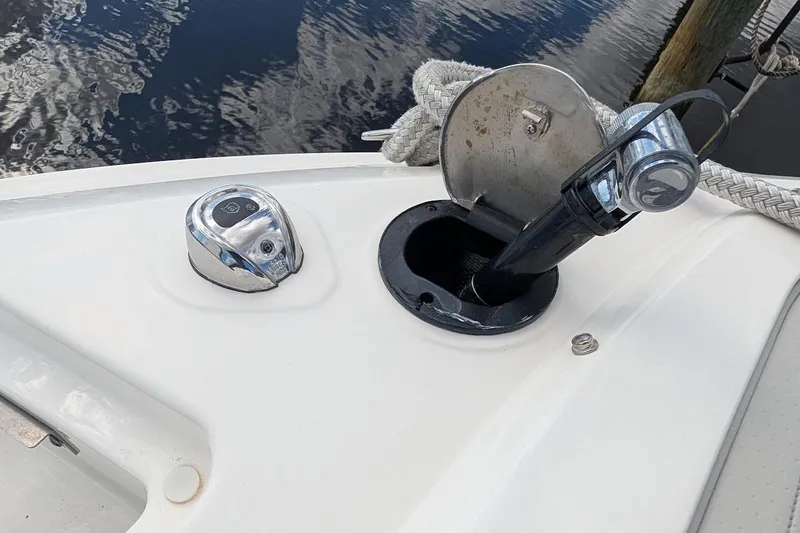Slide: The Image of 2023 Sea Ray 310 SLX boat anchor compartment with accessories and safety warning. - 25