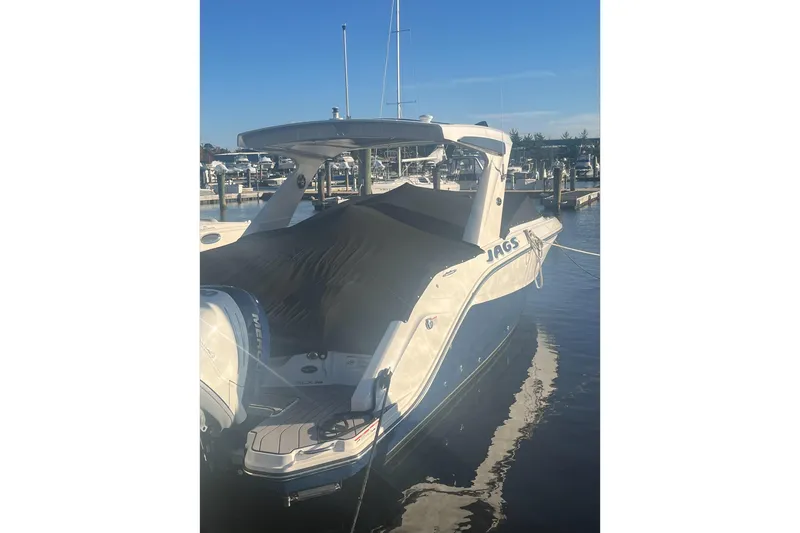 Slide: The Image of 2023 Sea Ray 310 SLX boat docked at marina under blue sky. - 27